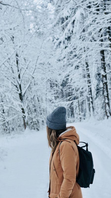 girl walking in snow with a bag