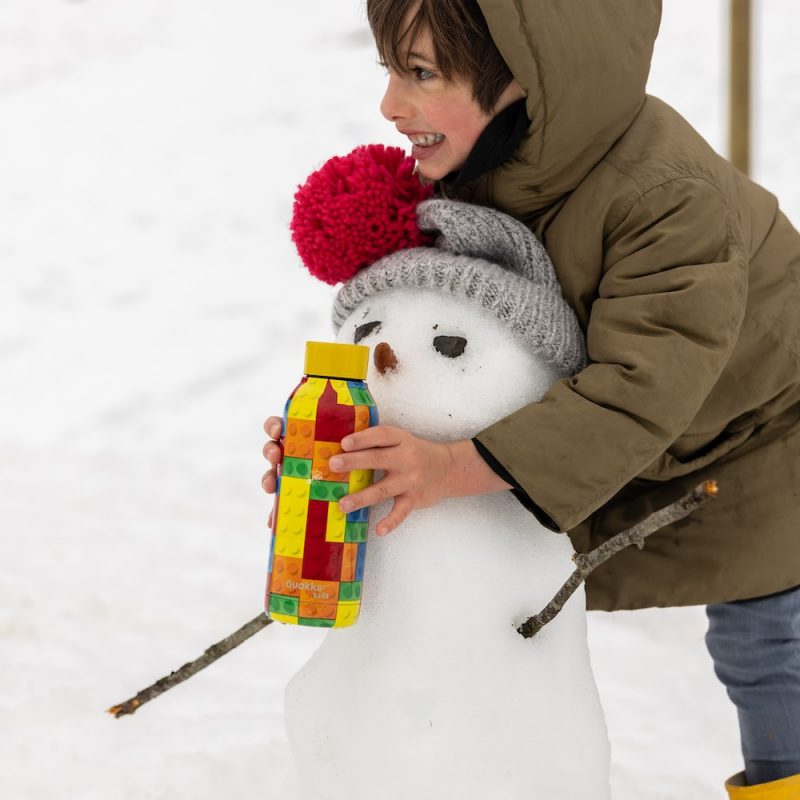 kid wearing warm winter clothes in snow